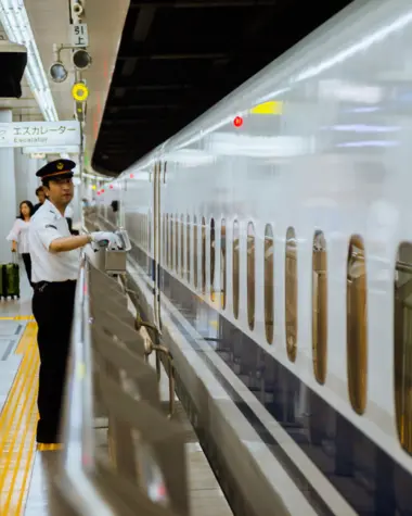 Personal del tren frente a un Shinkansen