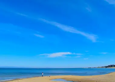 Une plage de sable au bord de l’océan sous un ciel bleu à Awaji