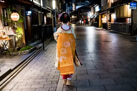 A geisha walking at night in Gion - Kyoto