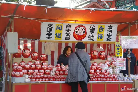 Durama doll stand. According to legend, when the eyes of the doll you draw, you have to make a wish.