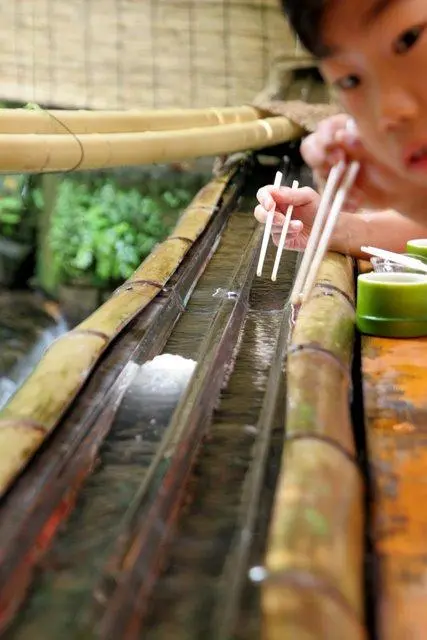 Un enfant essayant de saisir des nagashi-sômen à Kibune.