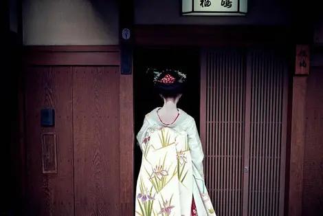 Geisha à l'entrée d'une maison de thé dans le quartier de Gion, à Kyoto