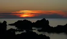 Sunset over rocks in the ocean from Sado Island