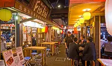 A busy street lined with izakaya