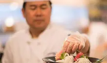 Un chef prepara un plato de sushi.