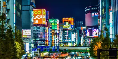 Neon lights of Shinjuku with car lights from a busy road